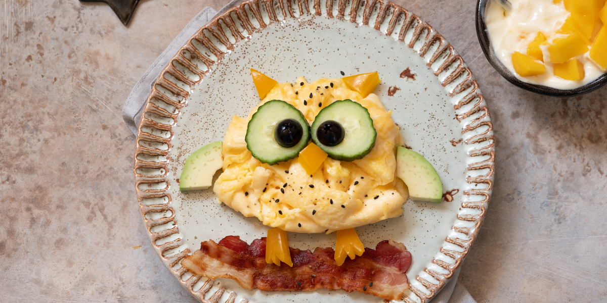 An egg owl perched on a bacon branch. Breakfast food art