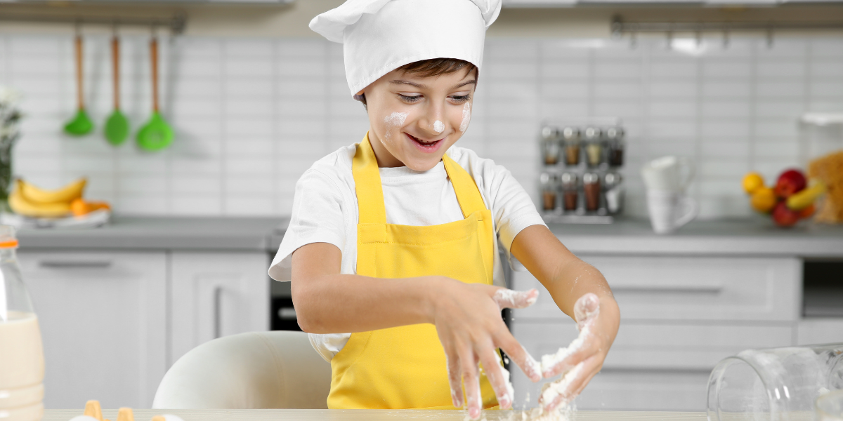 A young boy baking something