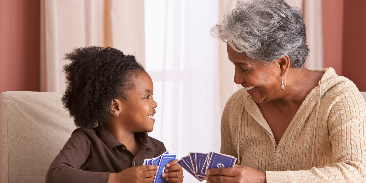 A grandma and her granddaughter playing cards together