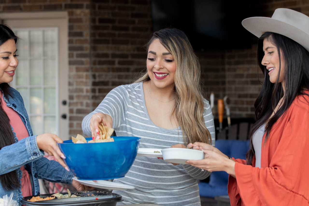 Group of women having meal together during backyard party