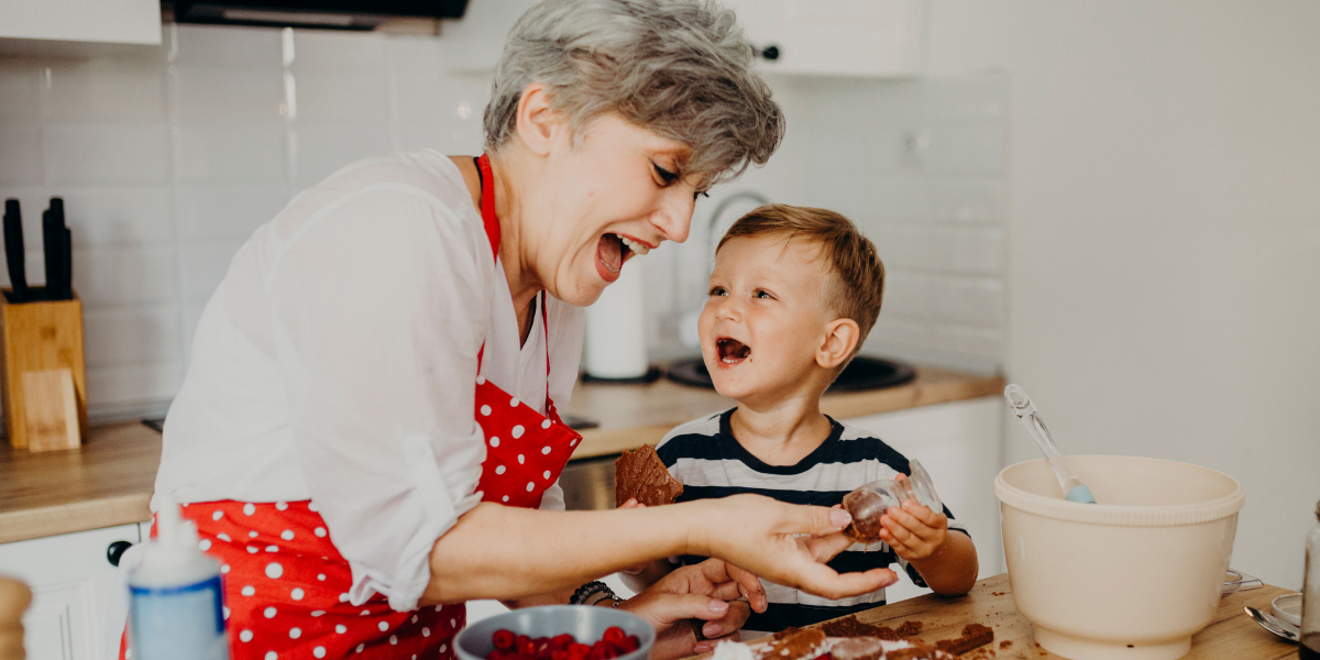 A little boy and his Grandma laughing and making yummy cookies in Grandma's kitchen