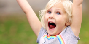 A little girl yelling and jumping for joy